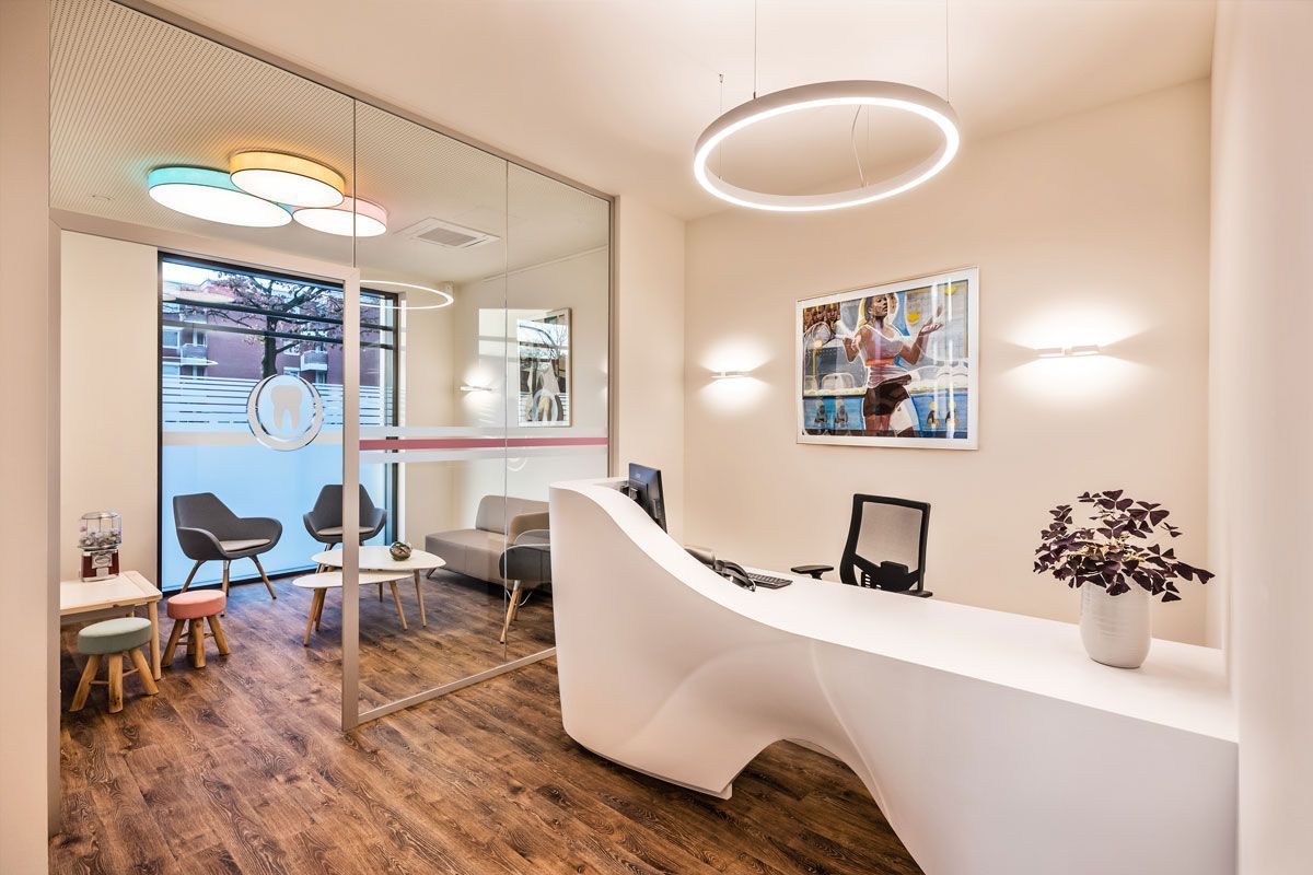 Ein Wartezimmer mit einem weißen Schreibtisch und Stühlen.