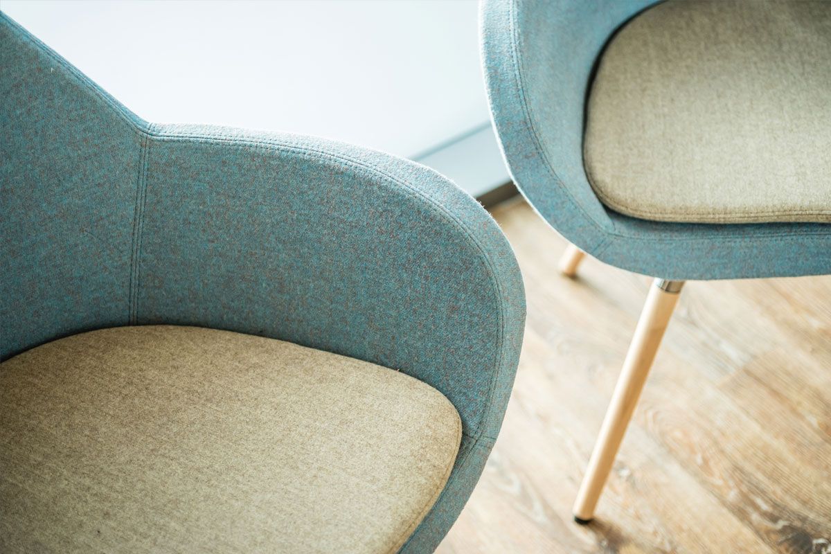 Zwei Stühle stehen nebeneinander auf einem Holzboden.