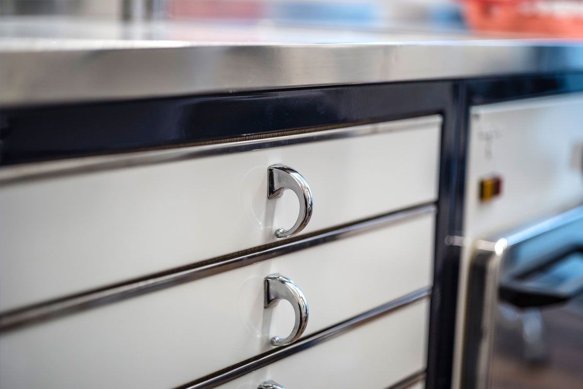 Eine Nahaufnahme einer Schublade mit einer Arbeitsplatte aus Edelstahl in einer Küche.