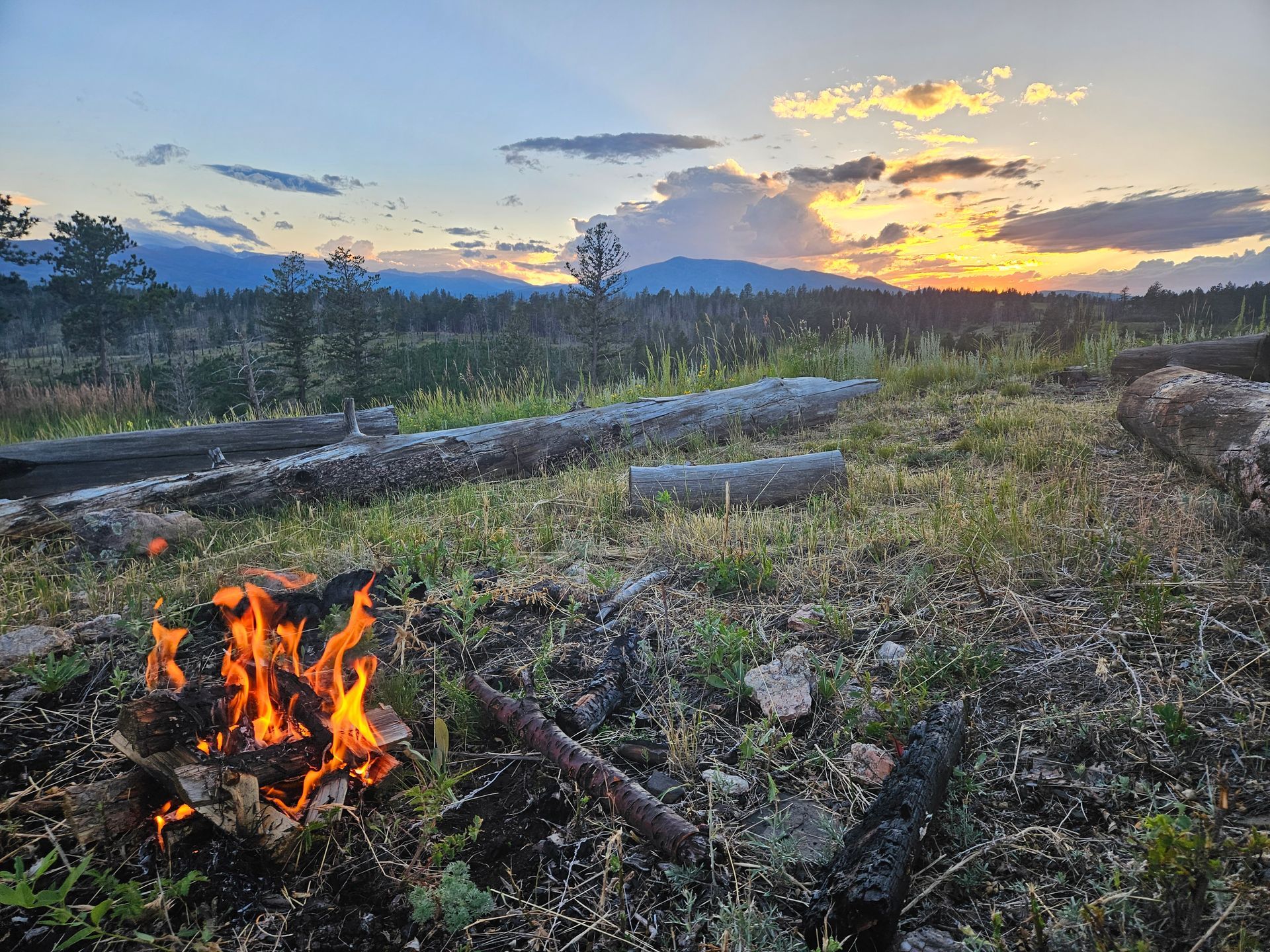 Rustic campfire overlooking sunset view.