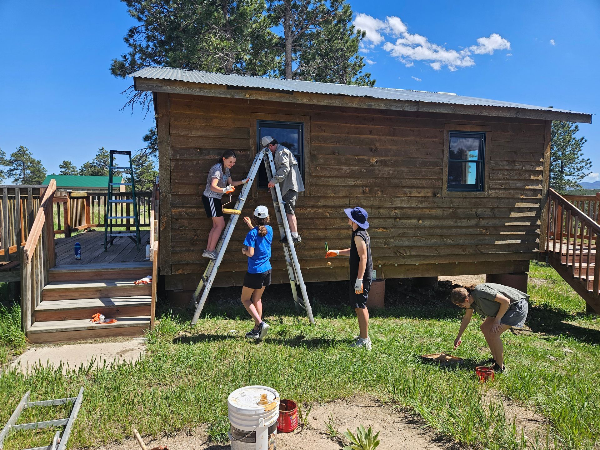 Volunteers staining a cabin