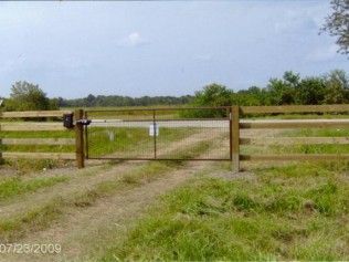 A metal gate within a wooden fence