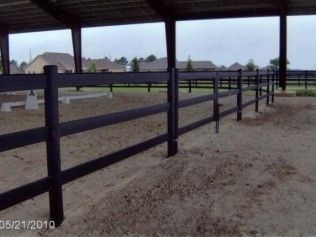 Black wooden fence in a sandy area under a shelter