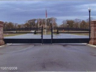 Black iron security gates on brick pillars