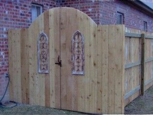 Wooden fence with arched gate and decorative arched window panels