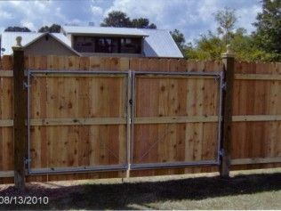 Wooden fence with double metal-framed gate