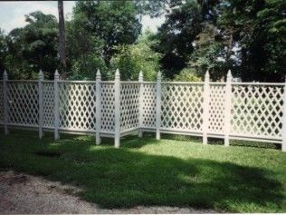 White lattice fence in a grassy yard