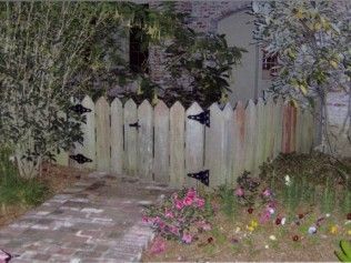 Wooden picket fence with black hinges