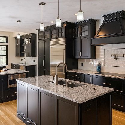 Modern kitchen with dark cabinets, granite island, stainless appliances, and hanging pendant lights