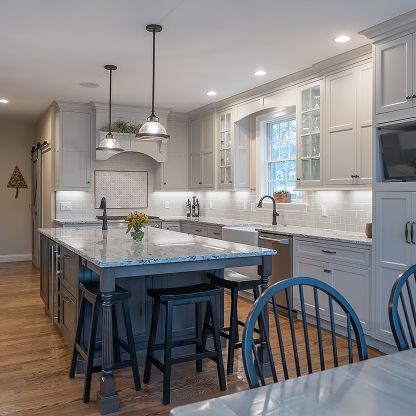Bright modern kitchen with gray cabinets, large island, pendant lights, and hardwood floors