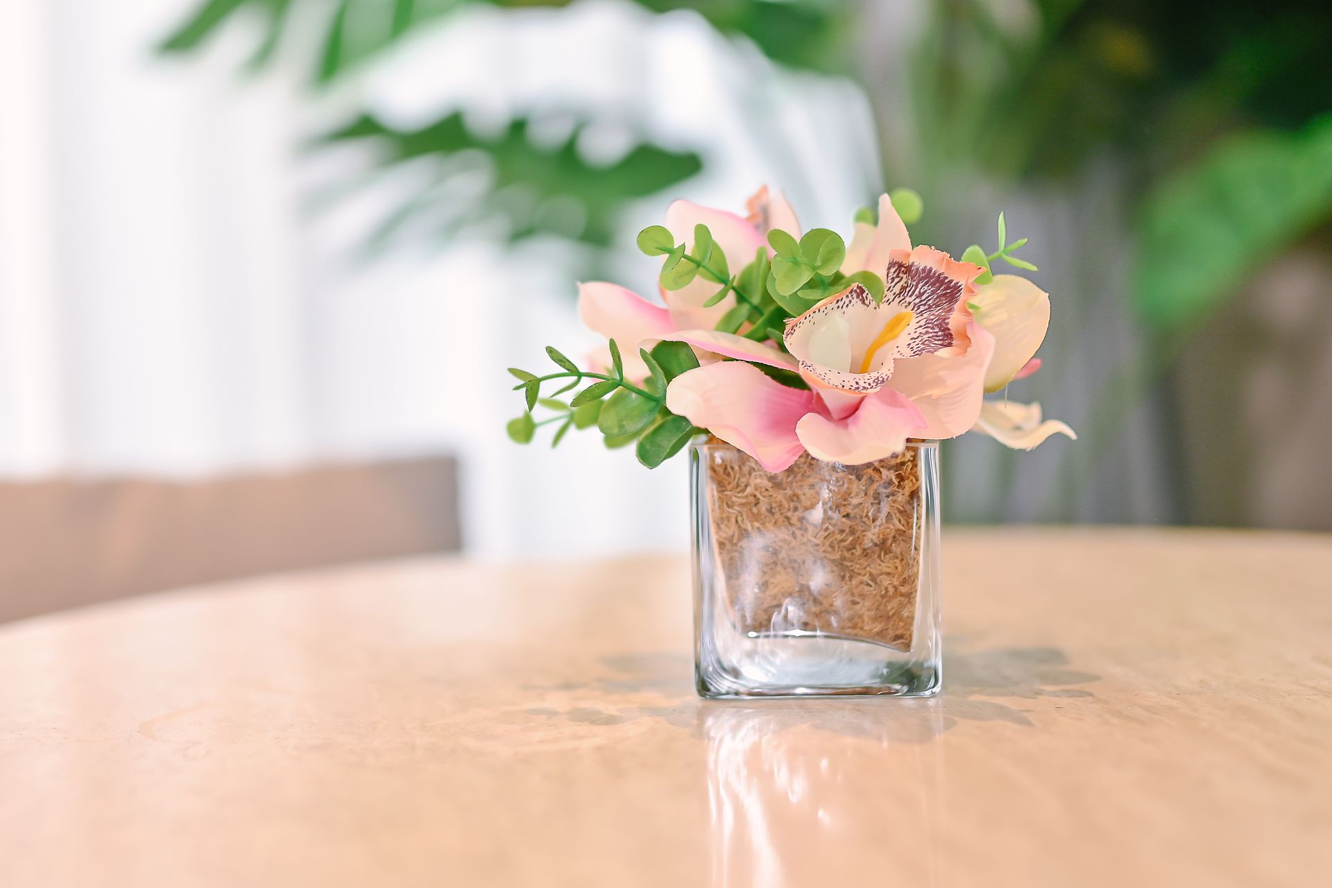 A vase filled with pink flowers is sitting on a table.