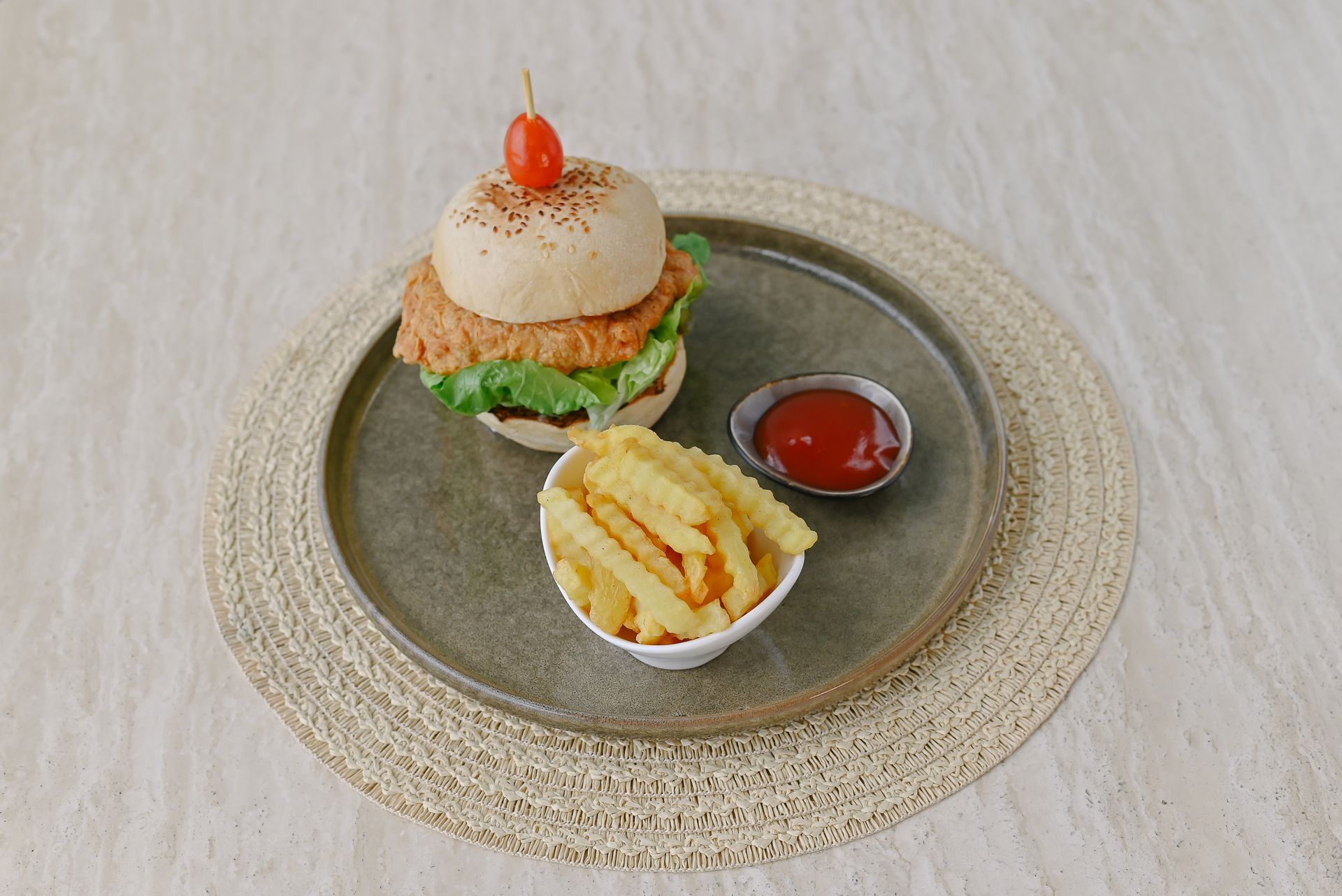 A hamburger and french fries on a plate on a table.