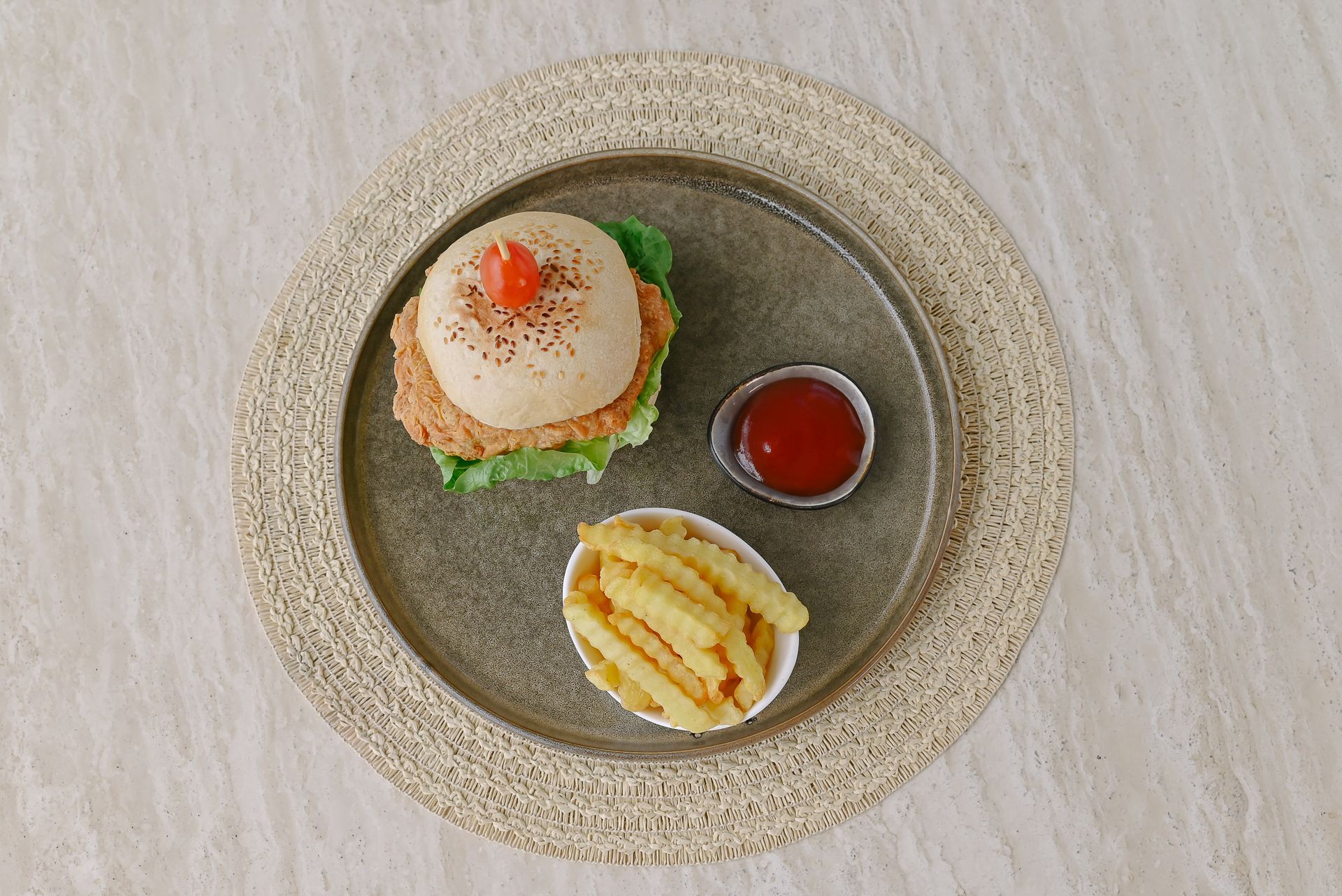 A hamburger and french fries on a plate with ketchup.