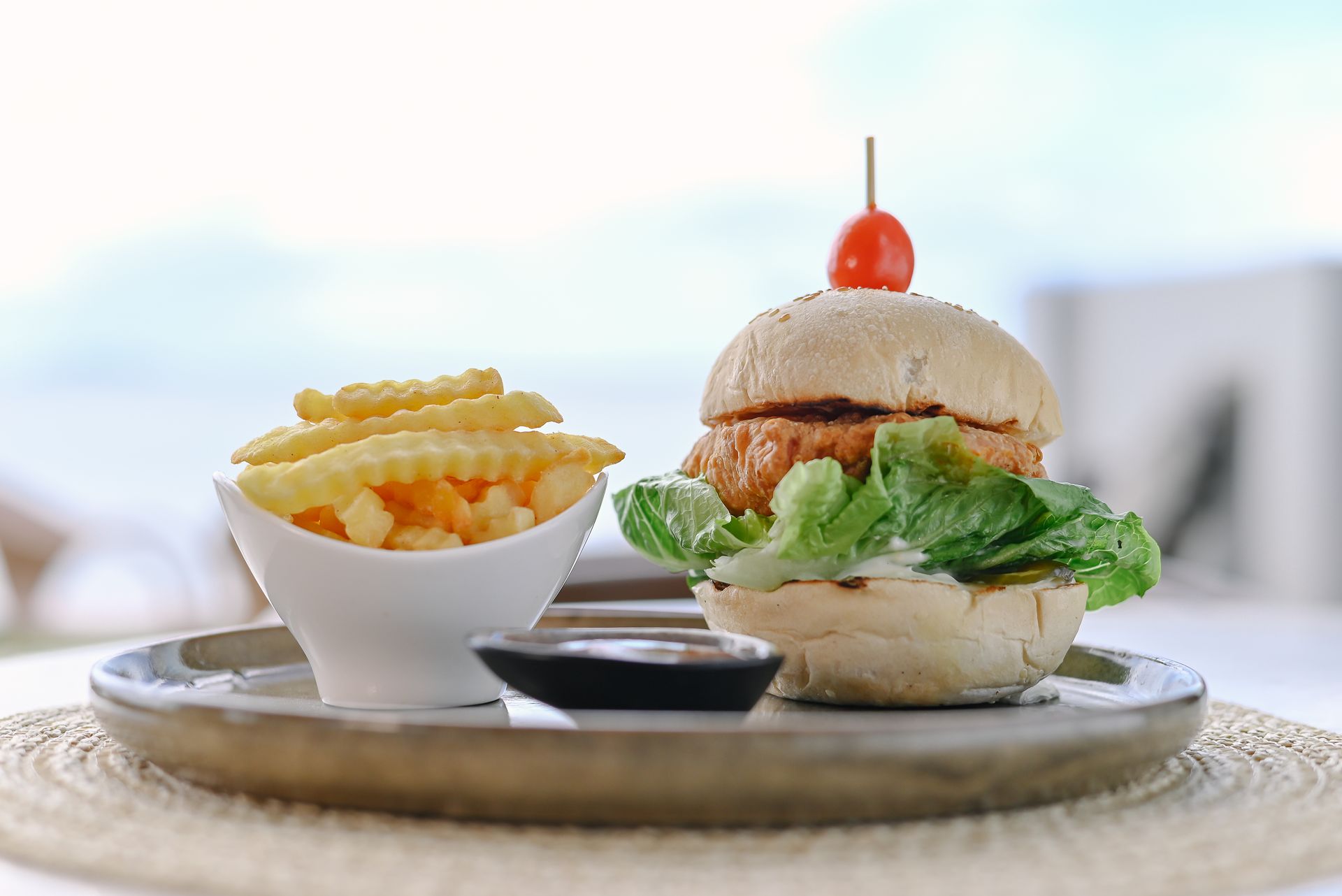 A hamburger and french fries on a tray on a table.
