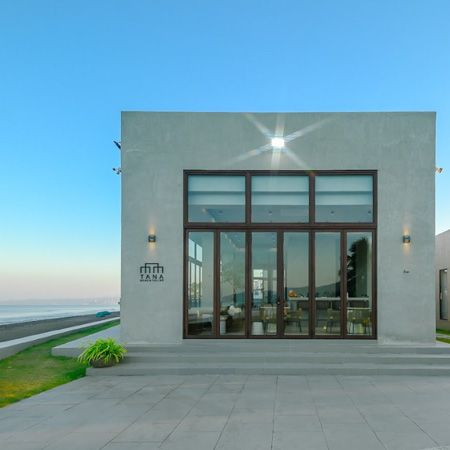 A white building with a lot of windows and a sign that says fifth casa