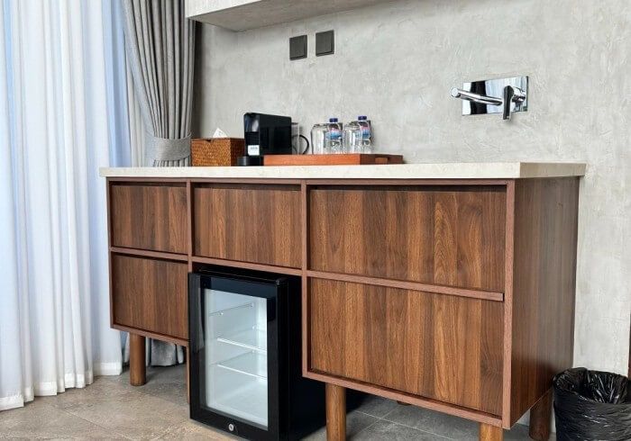A hotel room with wooden cabinets and a mini fridge.