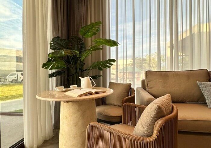 A living room with a couch , chair , table and window.