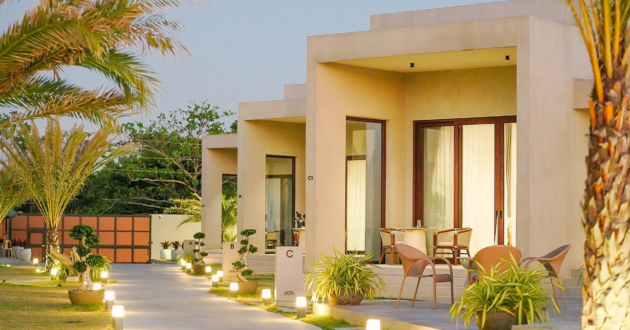 A row of houses with chairs and tables in front of them.