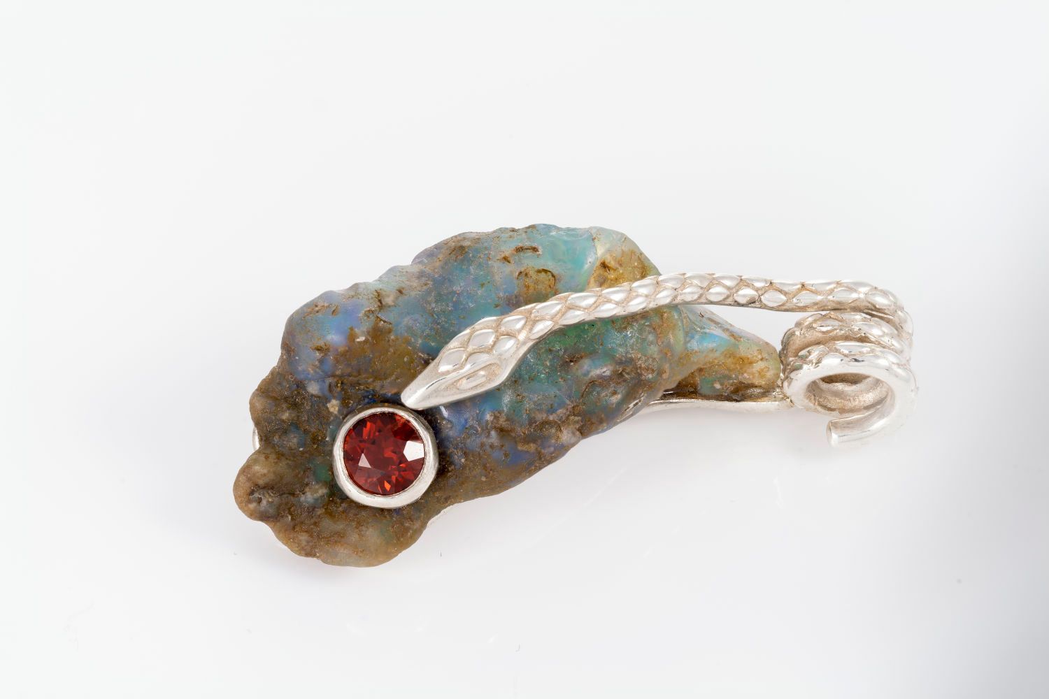 A brooch is sitting on top of a piece of rock.