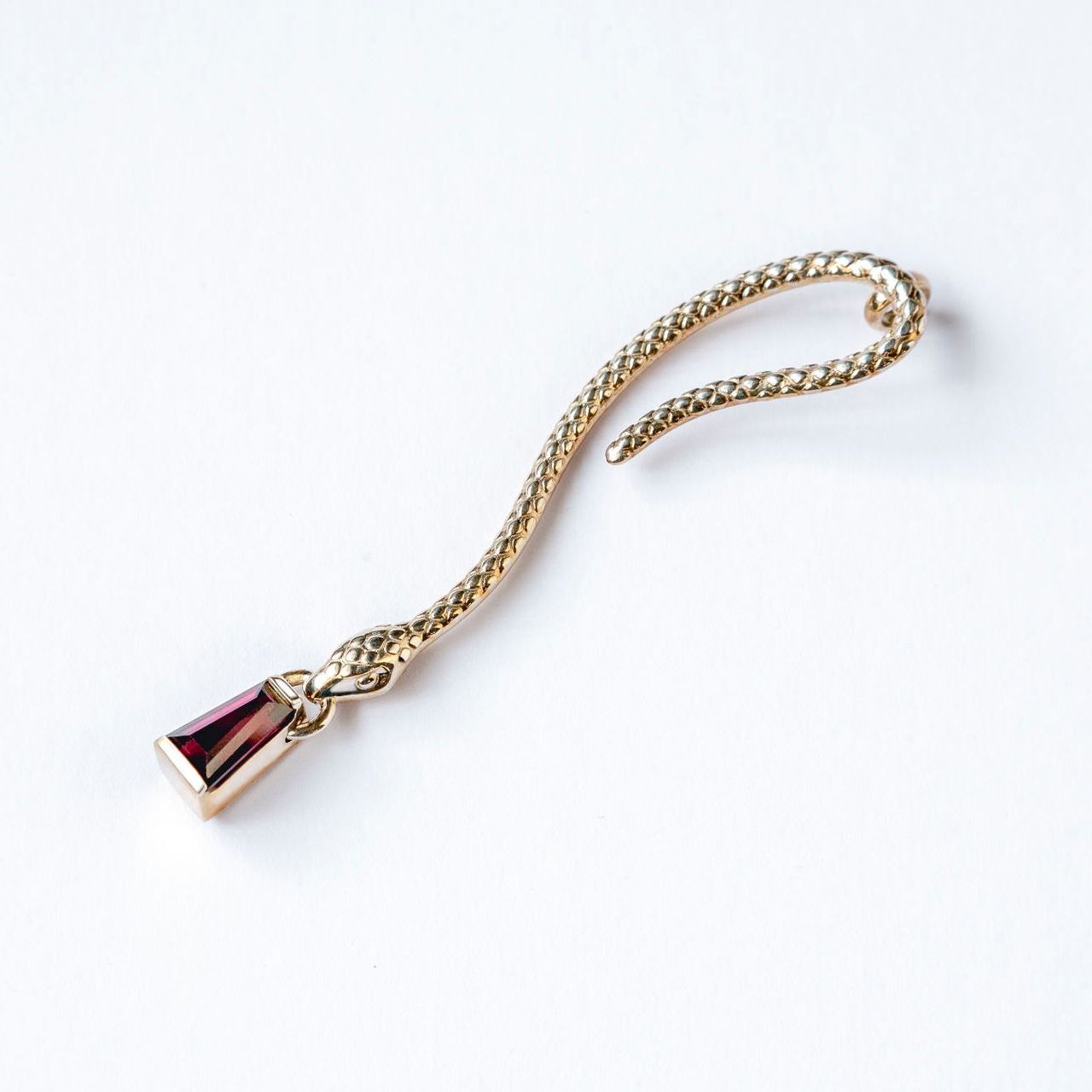 A gold chain with a pendant on it on a white background