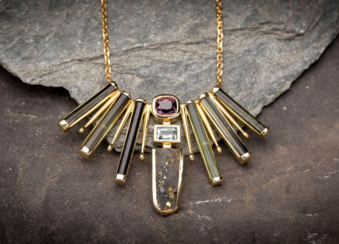 A necklace is sitting on top of a rock on a table.