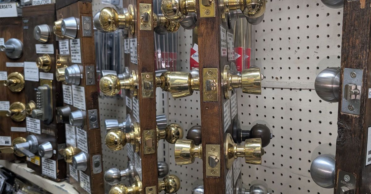 A bunch of door knobs are hanging on a wall in a store.