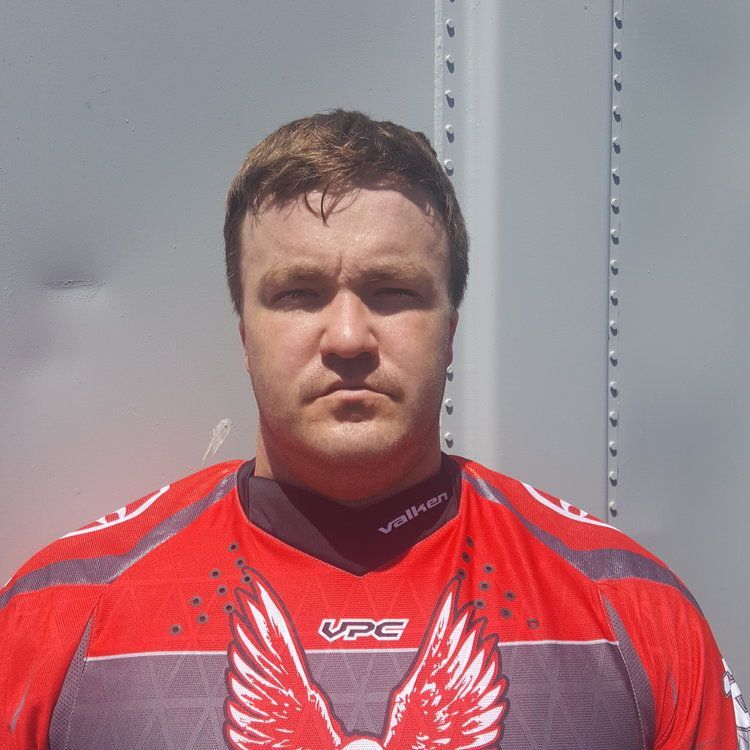 A man wearing a red vpc jersey with wings on it