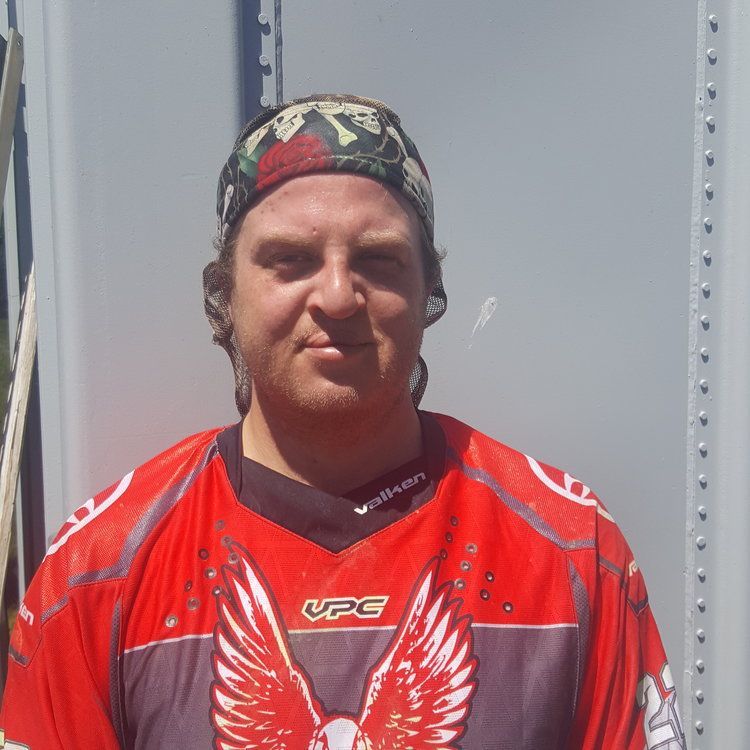 A man wearing a red shirt that says vpg on it