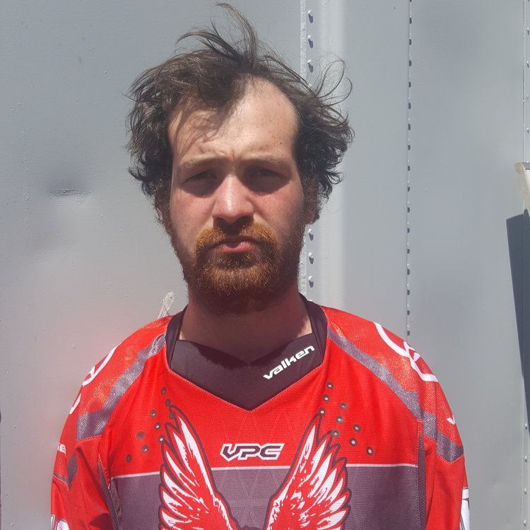 A man with a beard wearing a red vpc jersey