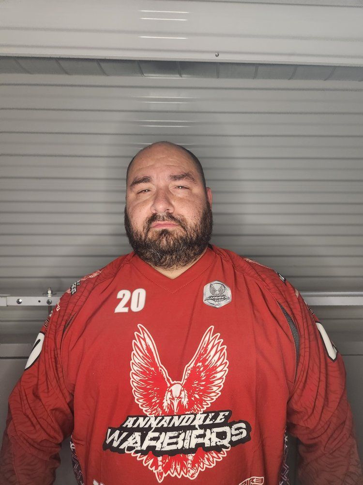 A man with a beard is wearing a red shirt with the number 20 on it.