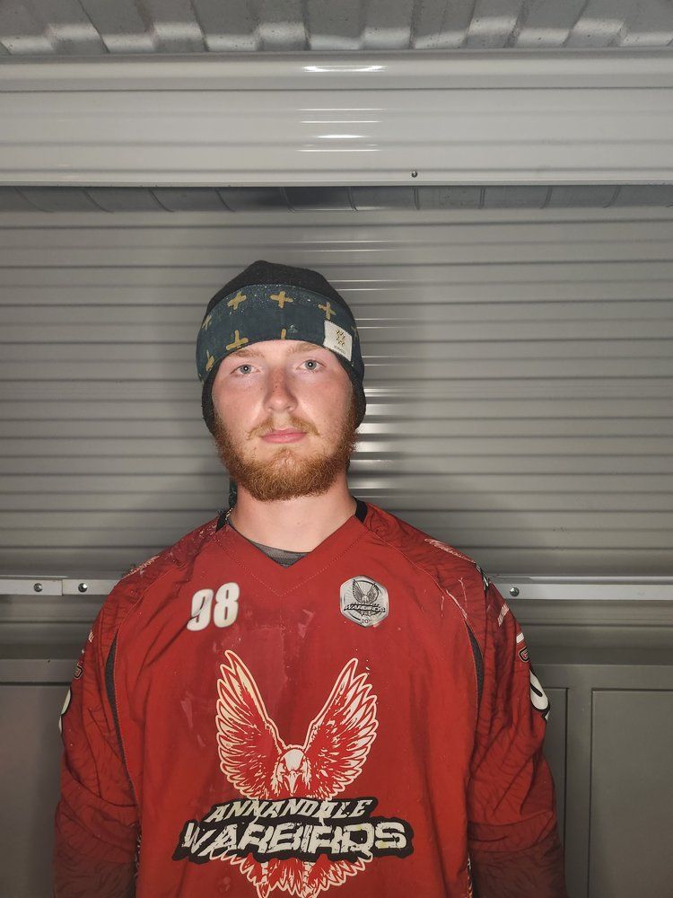 A man with a beard is wearing a red jersey with the number 98 on it.