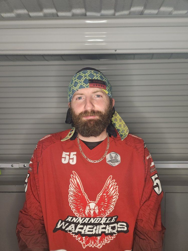 A man with a beard is wearing a red jersey and a bandana.