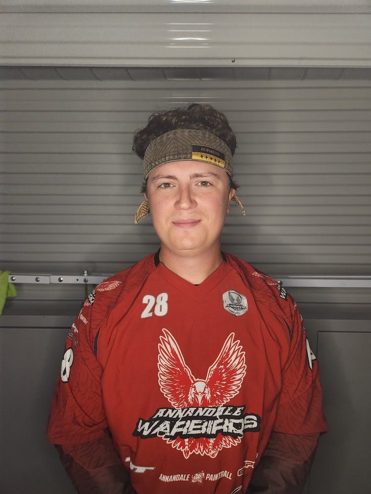 A young man wearing a red shirt with the number 28 on it.