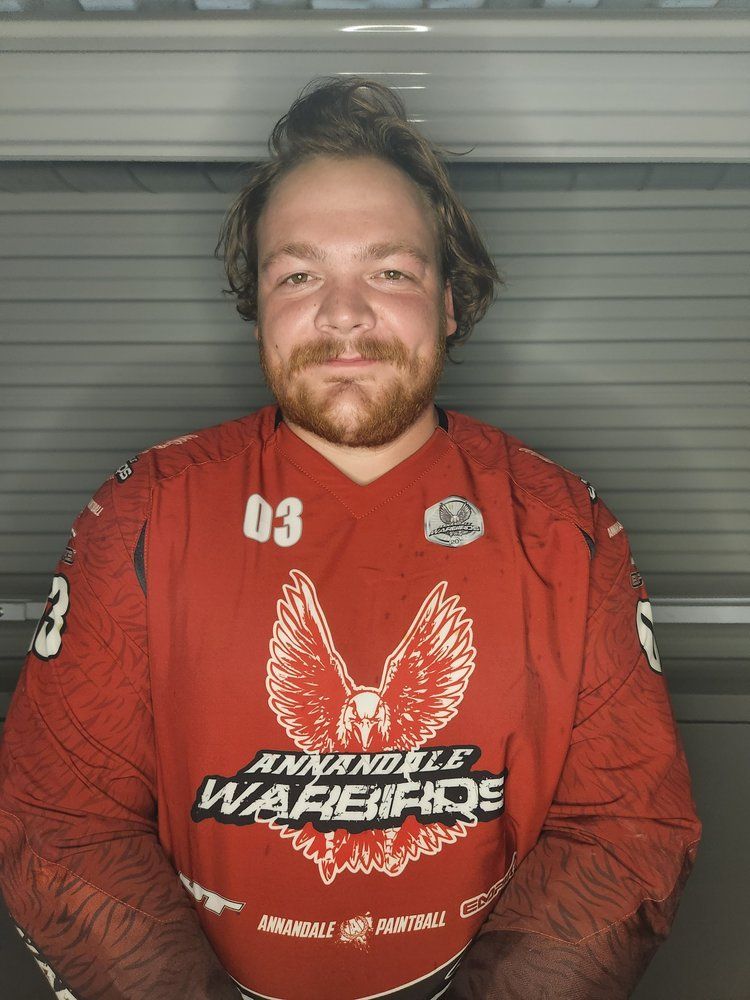 A man wearing a red shirt with the number 03 on it