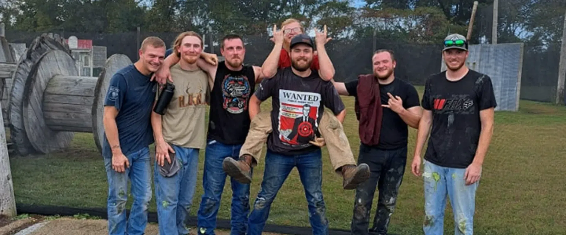 A group of young men are posing for a picture in a field.