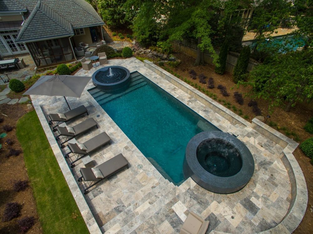 Inground geometric pool and spa with silver travertine
