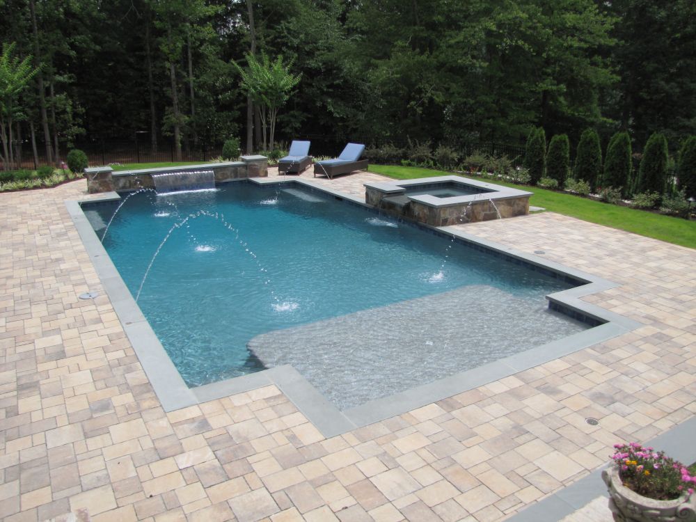 Inground geometric swimming pool with bluestone coping and paver decking
