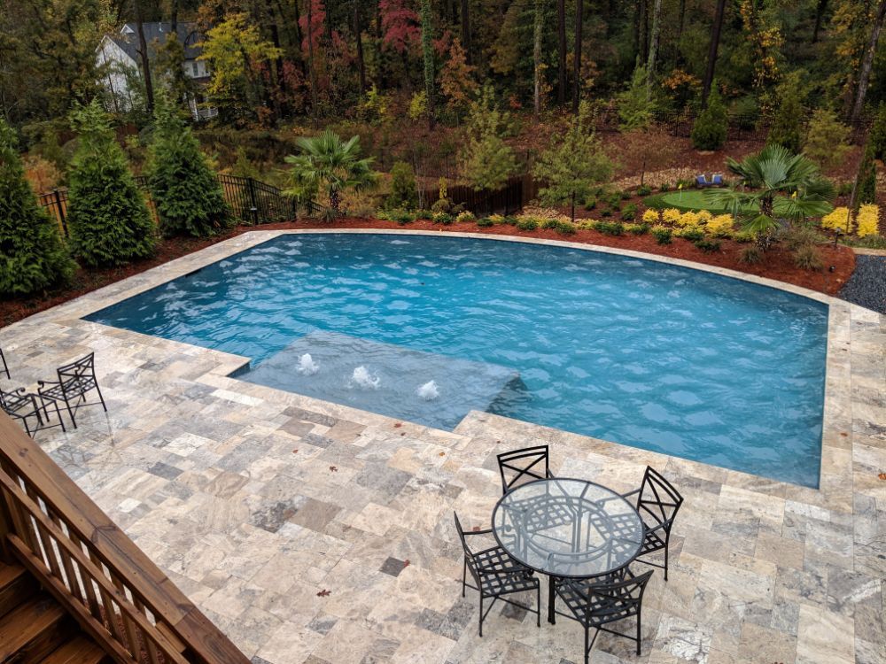 Inground geometric swimming pool with silver travertine