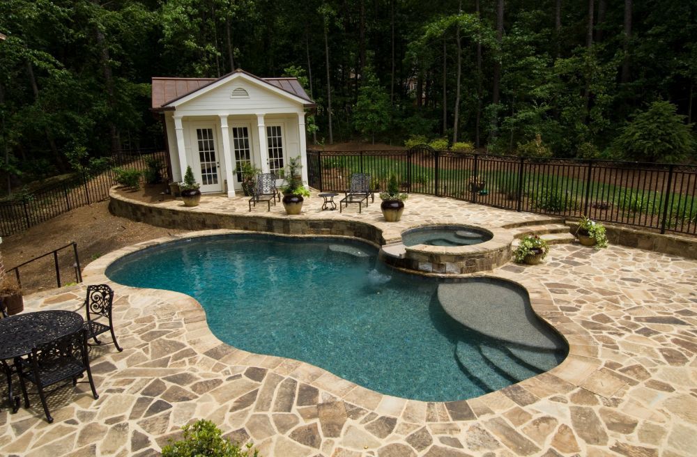 Inground swimming pool and spa with natural stone decking