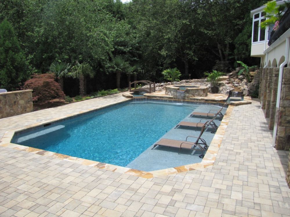 Inground swimming pool with long sunshelf