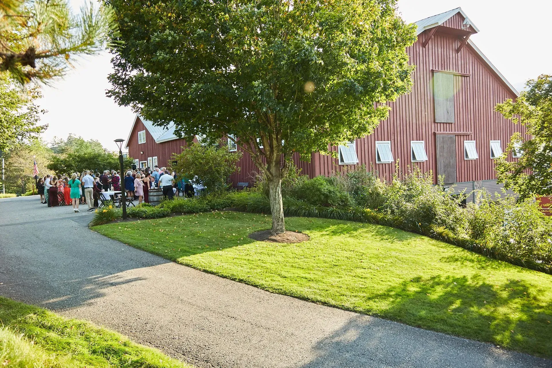 A group of people are standing in front of a red barn.