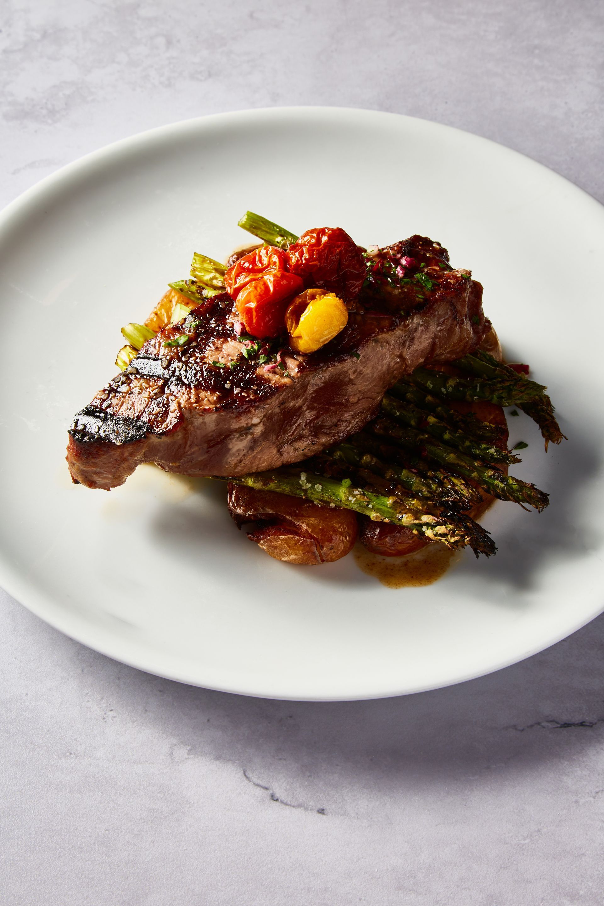 A white plate topped with a piece of meat and vegetables.