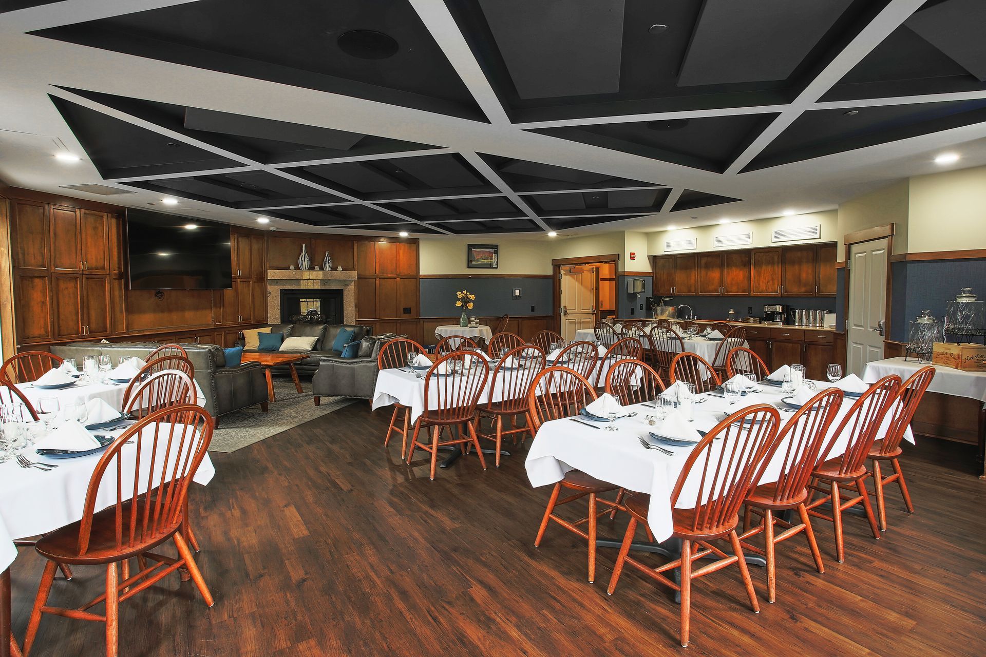 A large dining room with tables and chairs and a fireplace.