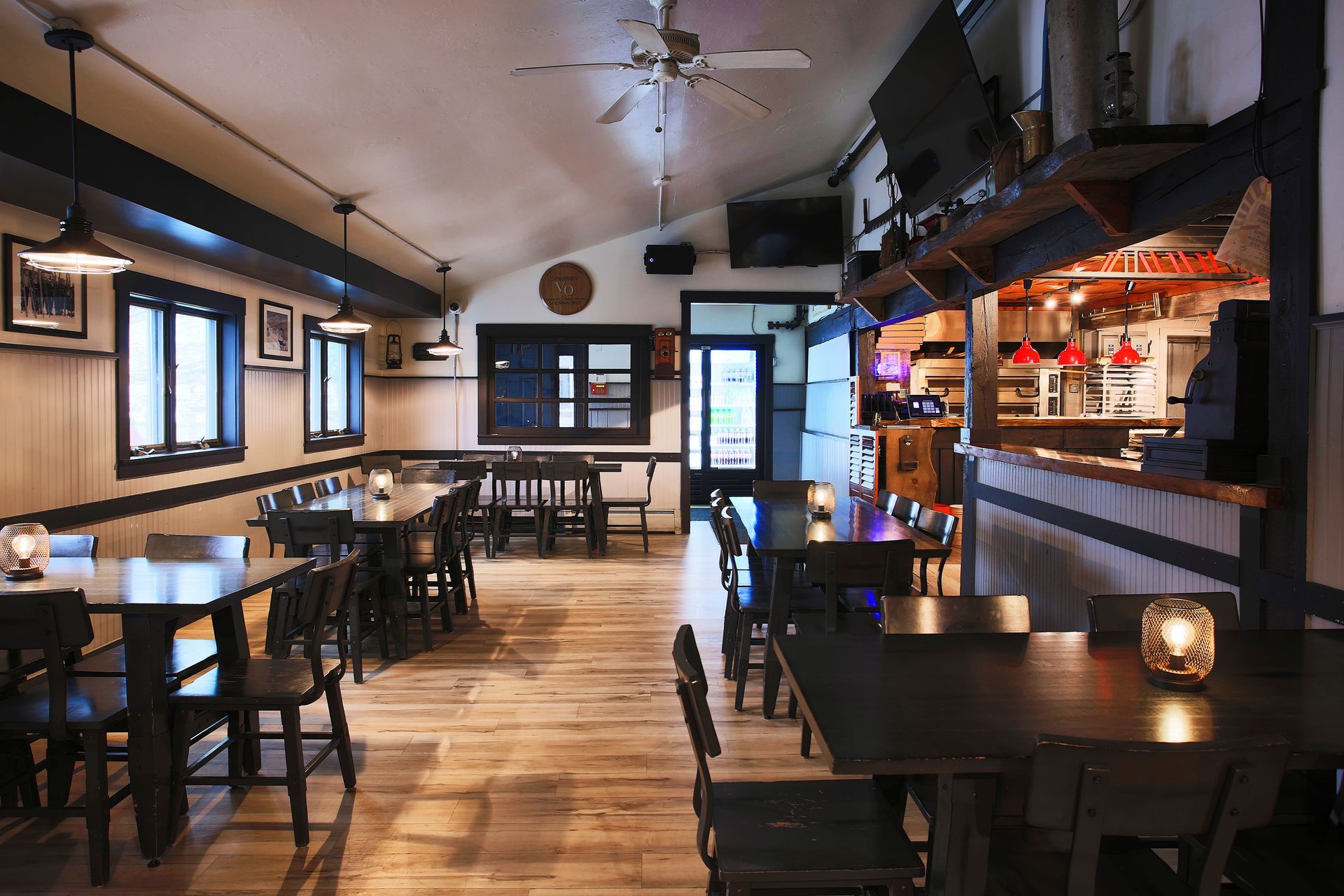 A restaurant with tables and chairs and a ceiling fan