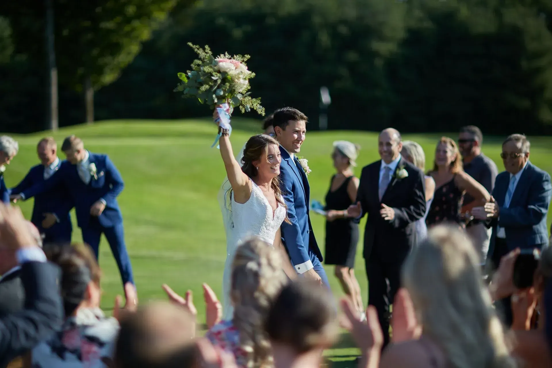 A bride and groom are walking down the aisle at their wedding.