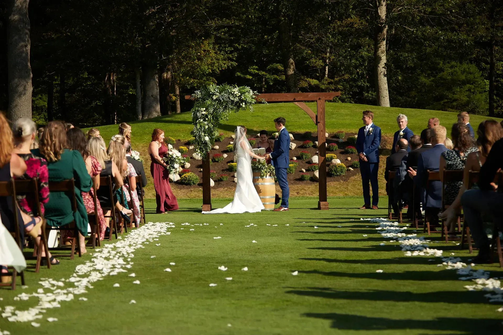 A bride and groom are getting married in front of a crowd of people.