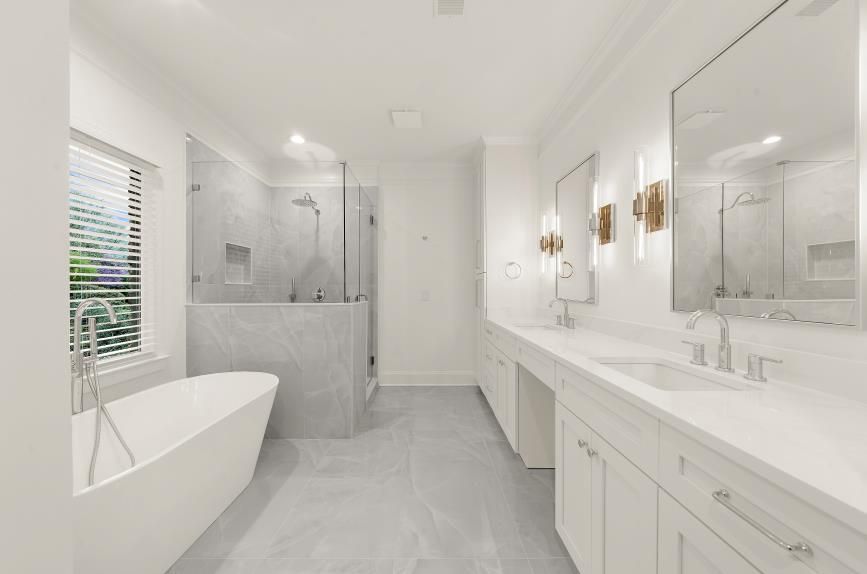 Bright modern white bathroom with freestanding tub, walk-in shower, and double vanity.