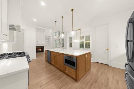 Bright modern kitchen with white cabinets, wood island, and pendant lights