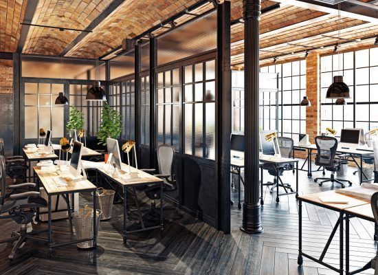 Modern open-plan office with desks, computers, black-framed glass partitions, and industrial wood-and-metal decor