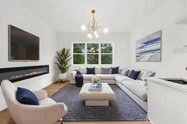Bright modern living room with a white sectional, blue accents, fireplace, and large window.
